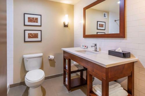 a bathroom with a toilet and a sink with a mirror at Comfort Inn & Suites Aberdeen in Aberdeen