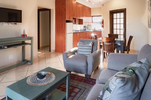 Pretoria的住宿－Tonder High Performance Center，带沙发和椅子的客厅以及厨房。