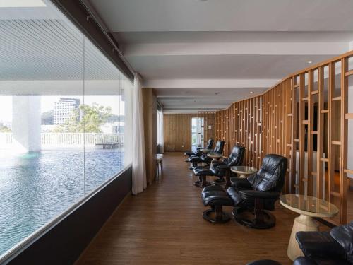 a waiting room with leather chairs and a large window at Novotel Phuket City Phokeethra in Phuket