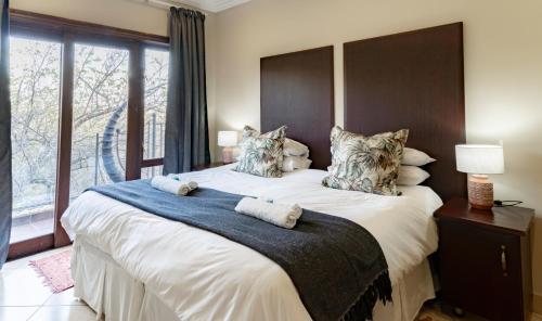 um quarto com uma cama grande e uma janela grande em Tonder High Performance Center em Pretoria