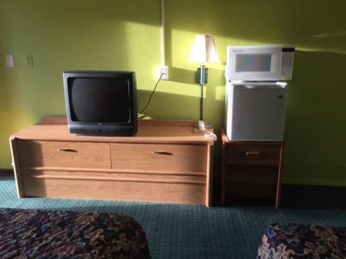 特雷霍特的住宿－Statesman Inn，一间酒店客房内的梳妆台上放了电视