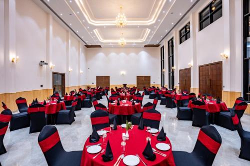 a large banquet hall with red tables and chairs at Shervani Pebbles & Pines Resort & Spa, Corbett in Rāmnagar