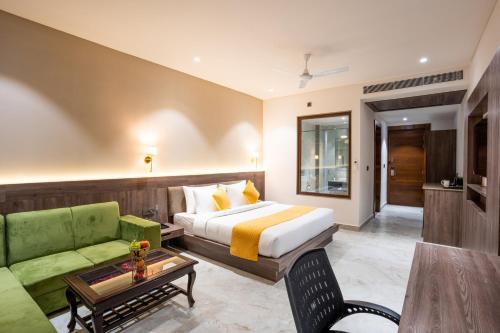 a hotel room with a bed and a green couch at Shervani Pebbles & Pines Resort & Spa, Corbett in Rāmnagar