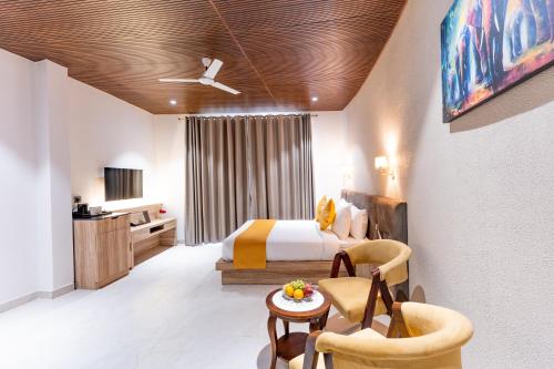 a hotel room with a bed and a table and chairs at Shervani Pebbles & Pines Resort & Spa, Corbett in Rāmnagar