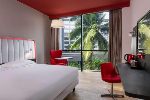 ein Hotelzimmer mit einem Bett und einem großen Fenster in der Unterkunft Park Inn by Radisson Libreville in Libreville