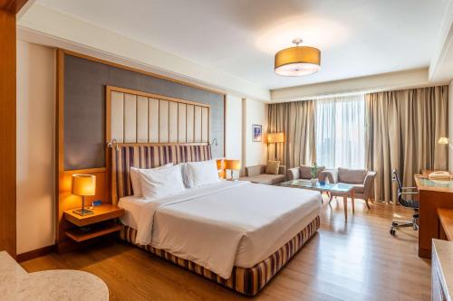 a hotel room with a bed and a living room at Radisson Blu Hotel, Indore in Indore