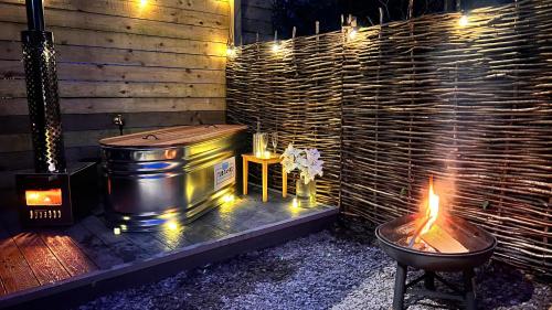 een hot tub en een vuurplaats met een grill bij Modern Shepherd's Hut Retreat for 2, Dog Friendly in Llangoed
