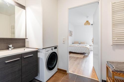 uma lavandaria com uma máquina de lavar roupa e um lavatório em GuestReady - Chic Hideaway near Paris em Saint-Ouen