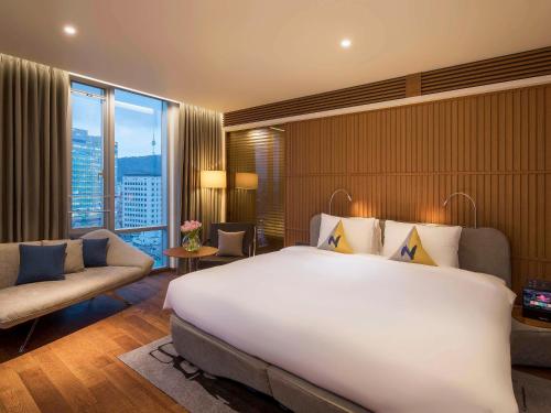 a hotel room with a large bed and a large window at Novotel Ambassador Seoul Dongdaemun Hotels & Residences in Seoul