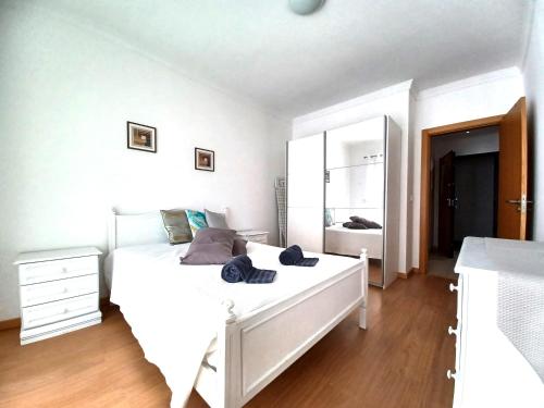 ポルティマンにあるEdificio Lumina Sunshine Beach Apartmentのベッドルーム(大きな白いベッド1台、鏡付)