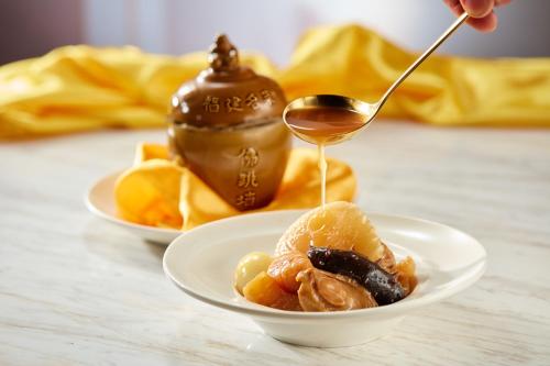 two bowls of food with a spoon and a pot of sauce at Galaxy Macau in Macau