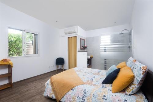 a bedroom with a bed with yellow and blue pillows at La Villa des Lataniers in Étang-Salé
