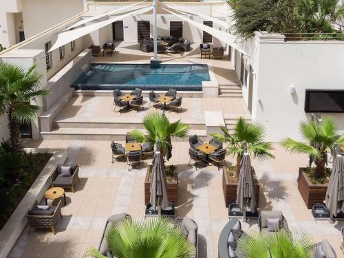 an overhead view of a pool with tables and chairs at Novotel Tunis Lac in Tunis