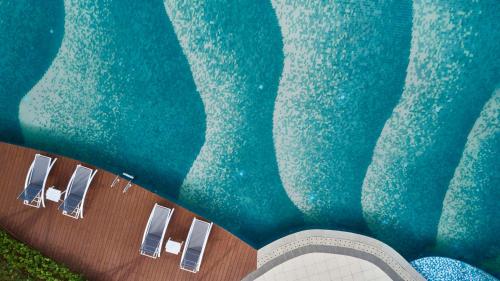 an overhead view of a swimming pool with three chairs at Hilton Garden Inn Guilin Yangshuo in Guilin