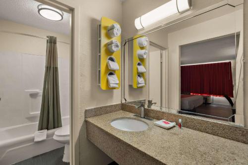 een badkamer met een wastafel, een toilet en een spiegel bij Econo Lodge in Yemassee