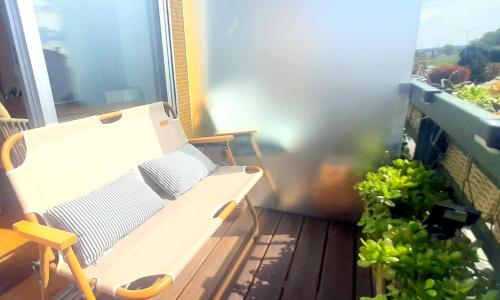 a white bench on a balcony with a plant at IH Apartments & Studios in Espinho