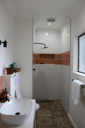 uma casa de banho com um chuveiro, um WC e um lavatório. em Luxurious Modern Beachfront Escape em Wilderness