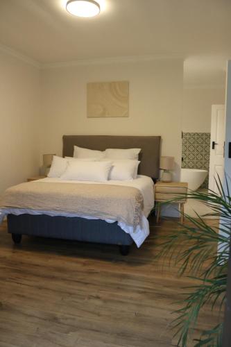 um quarto com uma cama com almofadas brancas em Luxurious Modern Beachfront Escape em Wilderness