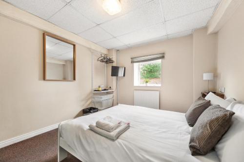 a bedroom with a white bed and a window at Riverside Mews in Brigg