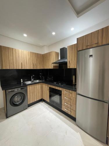 a kitchen with a stainless steel refrigerator and a dishwasher at Chic appartement au cœur du parc de Mohammedia in Mohammedia