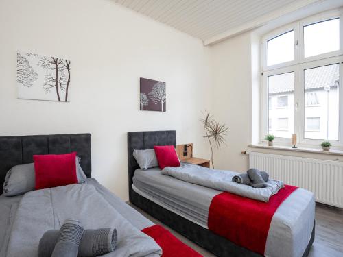 SR24 - Stillvolles gemütliches Apartment 5 in Recklinghausen في ريكلينغاوسين: سريرين في غرفة نوم حمراء ورمادية