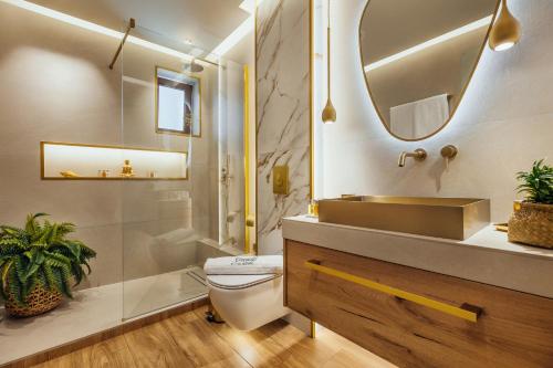 y baño con aseo, lavabo y espejo. en Emerald Deluxe Villas en Agios Nikolaos