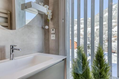 une salle de bain avec un lavabo et une fenêtre dans l'établissement Chalet Farniente, à Praz-sur-Arly