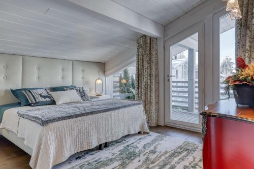 une chambre avec un lit et une grande fenêtre dans l'établissement Chalet Farniente, à Praz-sur-Arly