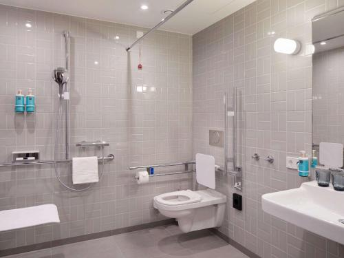 a bathroom with a toilet and a shower and a sink at Novotel Hamburg Central Station in Hamburg
