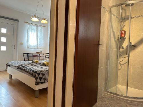 een slaapkamer met een bed en een glazen douche bij Rooms MARE in Poreč