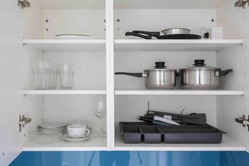 a kitchen with two pots and pans on shelves at Cozy Urban Studio in the City BE-41 in Zürich