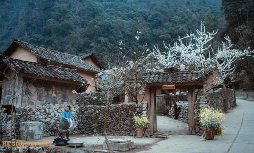a woman standing in front of a building at Mai's Homestay Dong Van in Dồng Văn