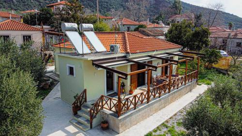 a house with a balcony with a roof at Myrtilli Cottages Pelion in Áno Lekhónia