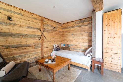 a room with a bed and a wooden wall at La cabane du cerf in Les Allues