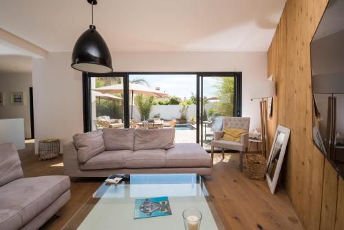 uma sala de estar com um sofá e uma mesa de vidro em Onofri plage em Saint-Cyr-sur-Mer
