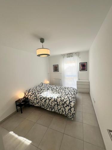 une chambre avec un lit dans une pièce blanche dans l'établissement Appartement cosy au cœur de Marseille, à Marseille