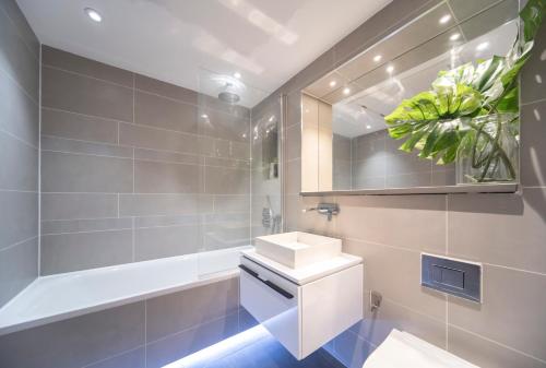 a bathroom with a sink and a mirror at Spacious & Smart Studio Flat with Balcony - Zone1 in London