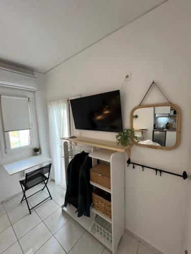 Zimmer mit einem TV und einem Spiegel an der Wand in der Unterkunft Para Thin Alos in Peraia