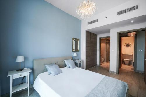 a bedroom with a large white bed and a bathroom at Hububb Luxury Studio One Marina in Dubai