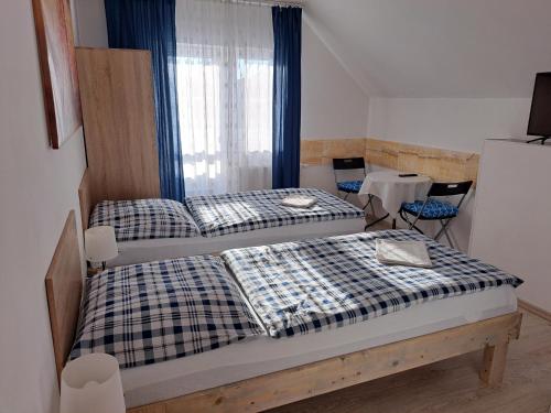 two twin beds in a room with a window at Apartmány Amália in Piešťany