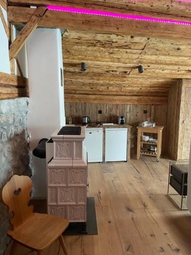 a kitchen with a stove in a room with wooden ceilings at Chasa Veglia in Sent