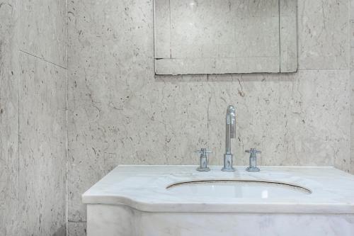 ein weißes Waschbecken im Bad mit Spiegel in der Unterkunft 2 Bedroom Apartment by AV Stays Short Lets Southwark London With Free WiFi in London