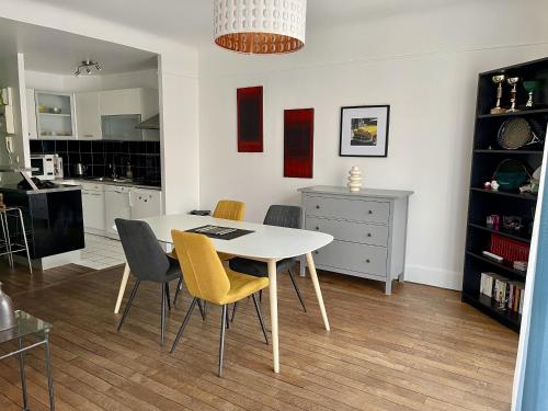 Il comprend une cuisine et une salle à manger avec une table et des chaises blanches. dans l'établissement Appartement Le Temple Auxerre Centre Ville, à Auxerre