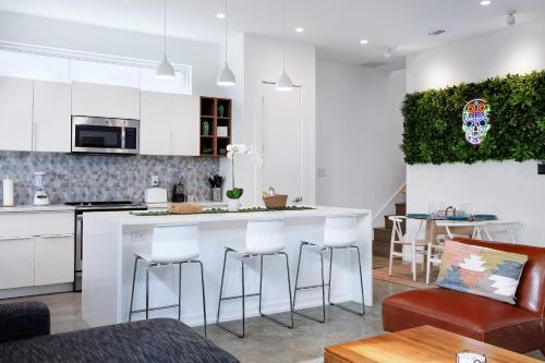 a kitchen with white cabinets and a bar with stools at Modern SA Home Nr DT River Walk Alamo WiFi in San Antonio
