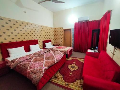 a bedroom with two beds and red curtains and a chair at Peridot Cottage in Islamabad