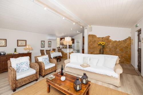 a living room with a couch and chairs and a table at Villa Irene in Mexilhoeira Grande