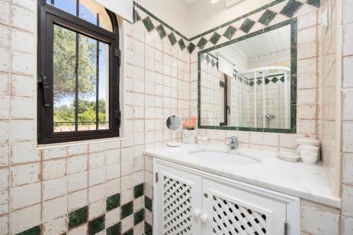 y baño con lavabo y espejo. en Villa Irene, en Mexilhoeira Grande