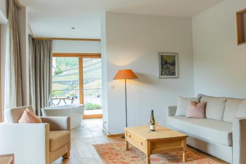 a living room with a couch and a table at Weinhaus Nigl - Hotel, Restaurant und Spa in Senftenberg