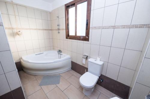 een badkamer met een toilet, een bad en een wastafel bij Anesis House in Stroumbi