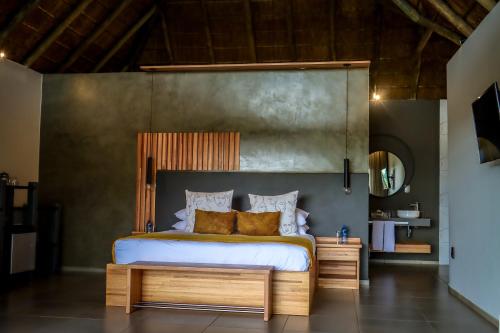 a bedroom with a large bed with a wooden headboard at La Joya Lodge Conference Centre and Spa in Pelindaba